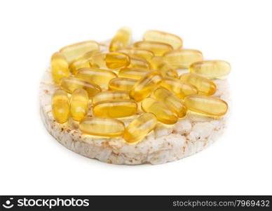 Sandwich from a round loaf and omega 3 pills. Isolate on white.
