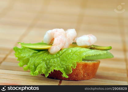 Sandwich garnish with shrimps, avokado and lettuce on bamboo napkin, snack