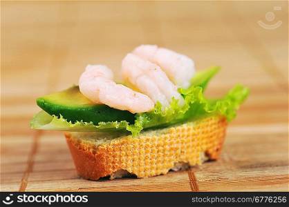 Sandwich garnish with shrimps, avokado and lettuce on bamboo napkin, snack