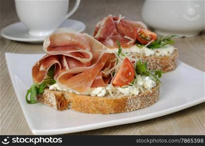 Sandwich of jamon with ricotta, arugula, cheese and a slice of cherry