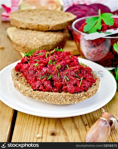 Sandwich with beetroot caviar and dill, garlic, bread, beets on a wooden boards background
