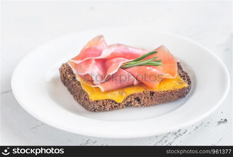 Sandwich with cheese and ham on the white plate