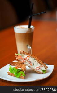 Sandwich with cheese and salmon and vegetables with latte