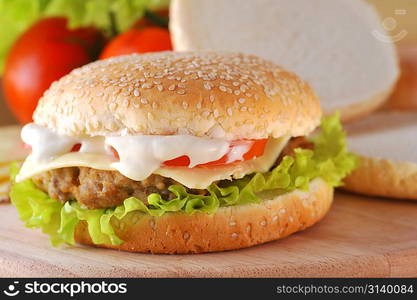 sandwich with cutlet and vegetables lies on plate