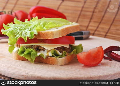 sandwich with cutlet and vegetables lies on plate