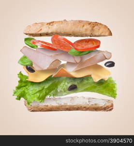 Sandwich with falling ingredients in the air - slices of fresh tomatoes, ham, cheese and lettuce