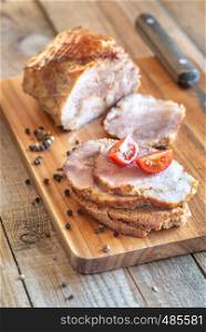 Sandwich with porchetta - Italian roasted pork on the wooden board