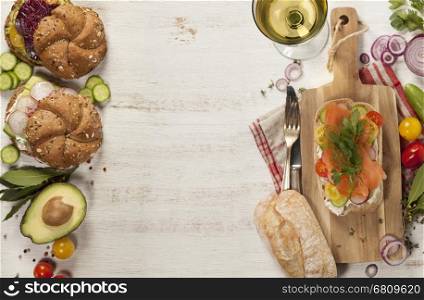 Sandwich with salmon, cucumber, cream cheese, dill and tomatoe on rustic wooden background.