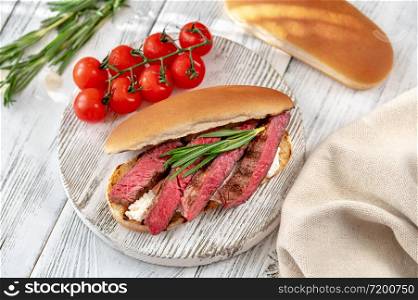 Sandwich with sliced beef steak, ricotta on the wooden board