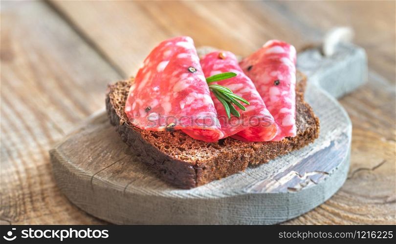 Sandwich with spanish salami on the wooden board