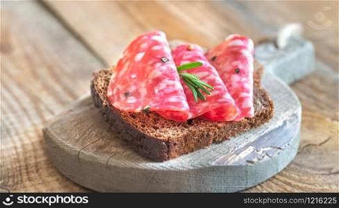Sandwich with spanish salami on the wooden board