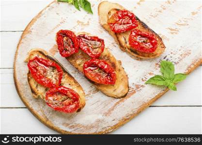 Sandwich with sun-dried tomatoes and herbs.Italian bruschetta. Bruschetta with sun dried tomatoes