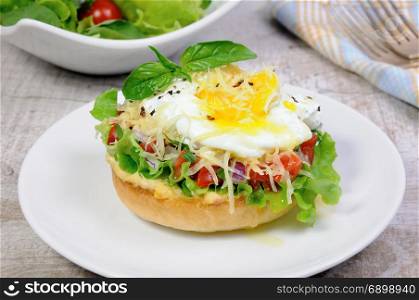 Sandwich with vegetable filling and egg poached, sprinkled cheese