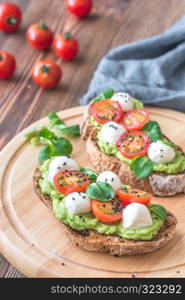 Sandwiches with avocado paste, cherry tomatoes and mozzarella