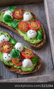 Sandwiches with avocado paste, cherry tomatoes and mozzarella