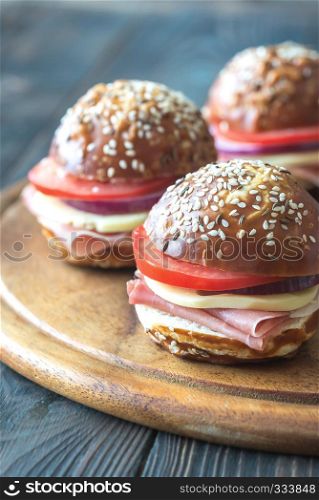 Sandwiches with cheese and ham on the wooden board