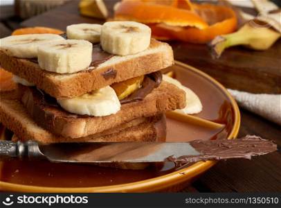 sandwiches with chocolate paste and banana slices on a plate, morning breakfast