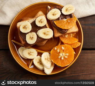 sandwiches with chocolate paste and banana slices on a plate, morning breakfast, top view