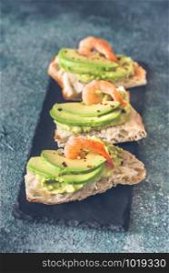 Sandwiches with guacamole, sliced avocado and shrimps
