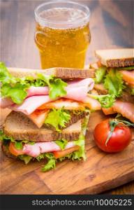 sandwiches with ham and smoked salmon with beer glasses