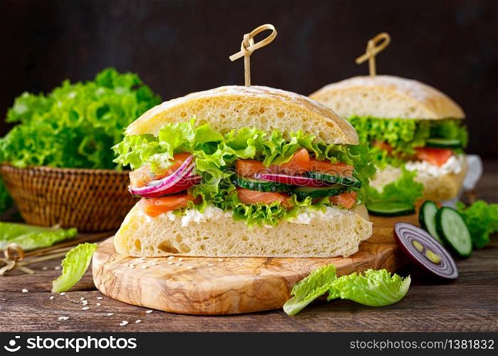 Sandwiches with homemade ciabatta bread, salted salmon fish, feta cheese, cucumber, onion and fresh lettuce salad, italian cuisine