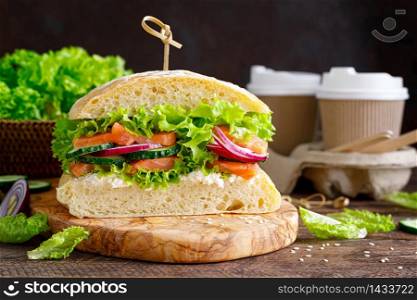 Sandwiches with homemade ciabatta bread, salted salmon fish, feta cheese, cucumber, onion and fresh lettuce salad, italian cuisine