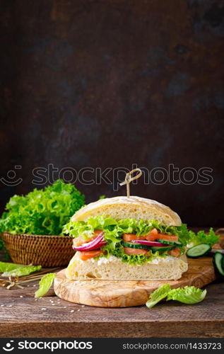 Sandwiches with homemade ciabatta bread, salted salmon fish, feta cheese, cucumber, onion and fresh lettuce salad. Sandwiches with homemade ciabatta bread, salted salmon fish, feta cheese, cucumber, onion and fresh lettuce salad, italian cuisine