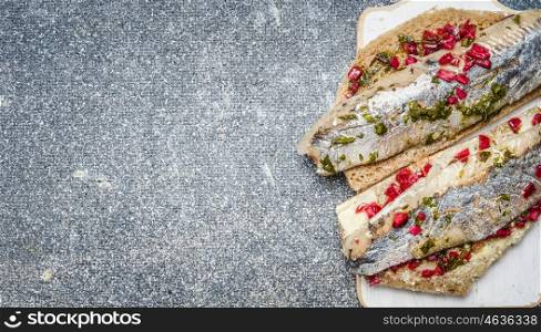 Sandwiches with pickled herring on gray background, top view, place for text