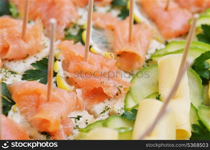 Sandwiches with red fish and greens on wooden chopsticks