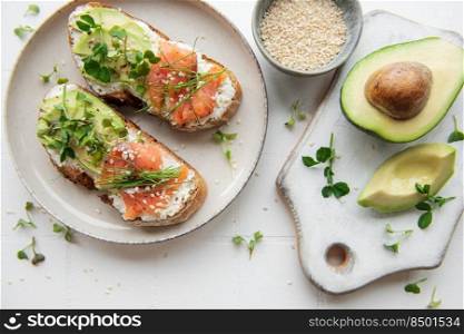 Sandwiches with sa<ed salmon,  avocado andµgreens.  Hea<hy food.