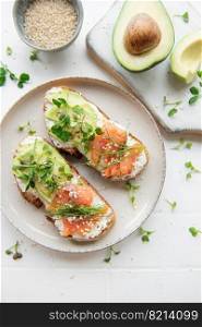 Sandwiches with salted salmon,  avocado and microgreens.  Healthy food.