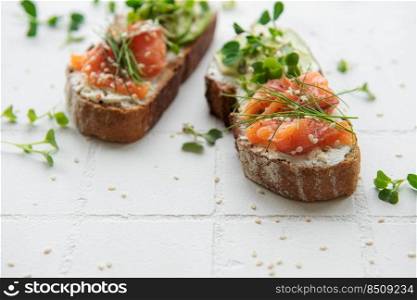 Sandwiches with salted salmon,  avocado and microgreens.  Healthy food.