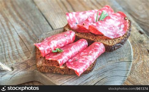 Sandwiches with spanish salami on the wooden board