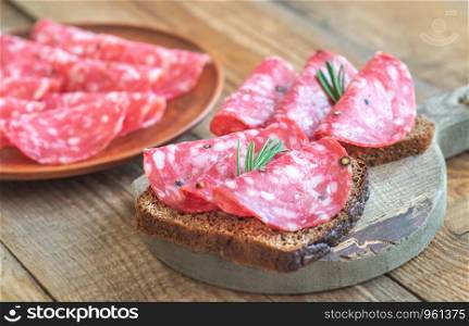 Sandwiches with spanish salami on the wooden board
