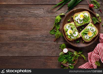 Sandwiches with wholemeal bread, hummus or puree of fresh green peas, radish, cucumber, boiled egg, green onion and chard
