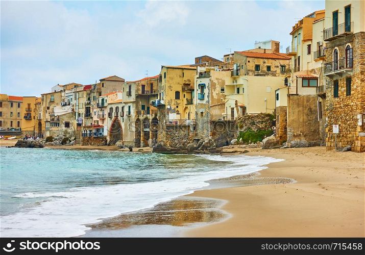 Sandy beach and old houses by the sea in Cefalu, Landmark and seaside resort in Sicily, Italy