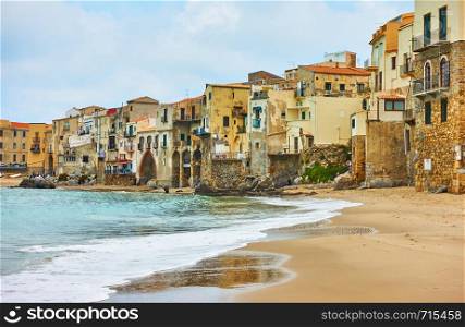 Sandy beach and old houses by the sea in Cefalu, Landmark and seaside resort in Sicily, Italy