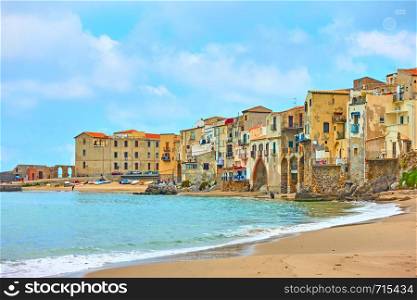 Sandy beach and old houses by the sea in Cefalu, Sicily, Italy