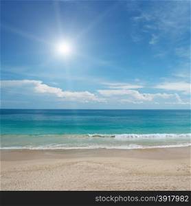 Sandy beach and sun in blue sky