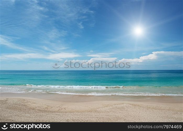 Sandy beach and sun in blue sky