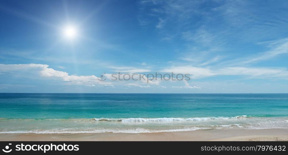 Sandy beach and sun in blue sky