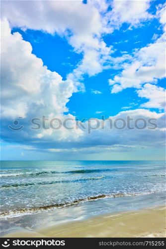 Sandy beach and white heap clouds in the sky