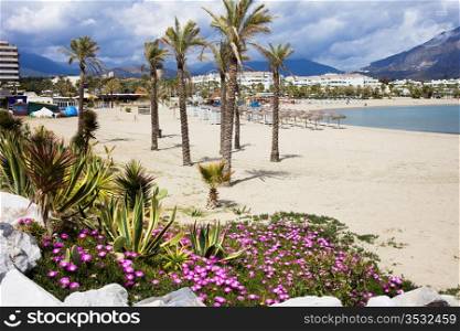Sandy beach in resort town of Puerto Banus (near Marbella) on scenic Costa del Sol, Andalusia, Spain.