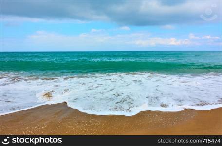 Sandy beach of seaside resort and waves with white foam - Background