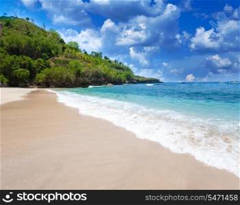 Sandy beach of the sea and green hills. Indonesia. Bali