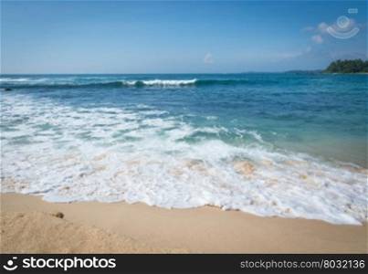 Sandy paradise beach with golden sand and emerald green water on the edge of Indian Ocean, Southern Province, Sri Lanka, Asia.