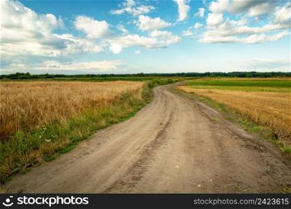 Sandy road through farmland and clouds to the sky, Czulczyce, Lubelskie, Poland