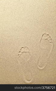 Sandy summer beach background with footprints. Copy space