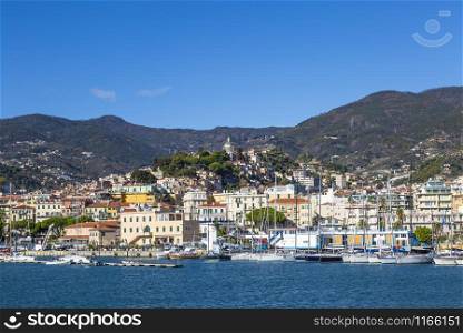 Sanremo, Italy ? November 14, 2017 - sunny day view from the sea with boats and yachts to the old town of Sanremo (La Pigna) and Madonna della Costa Church on the hilltop, Liguria, Italy