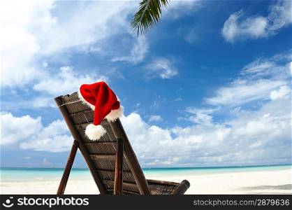 Santa&acute;s hat and chaise lounge on the beach